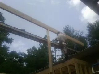 Carpenter setting a ridge beam over a new addition frame — Ice Dam Removal by Roofing Brothers in Englishtown