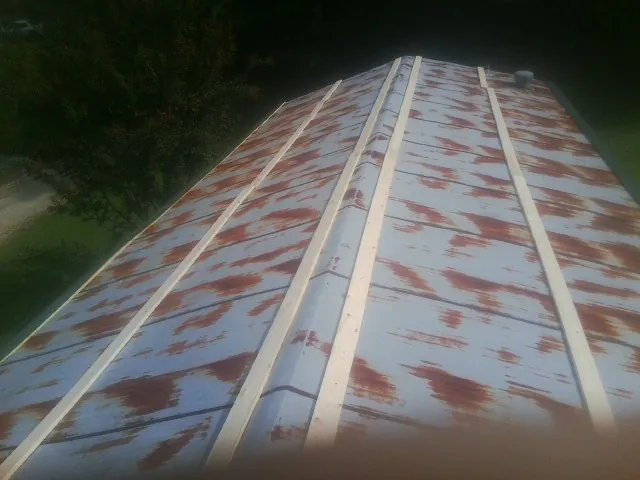 Rusted metal roof panels with new wood purlins before replacement — Storm Damage Roof Repair in Englishtown by Roofing Brothers