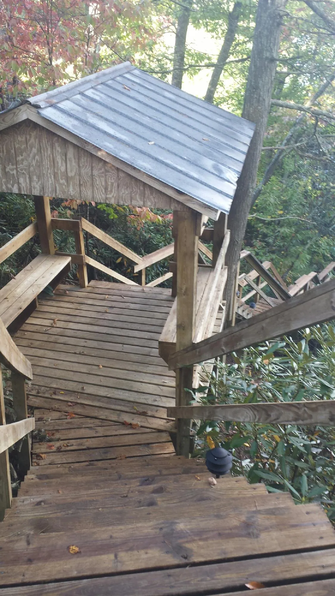 Metal roofed shelter over wooden steps on a wooded walkway — Skylight Repair & Installation work by our crew in Englishtown
