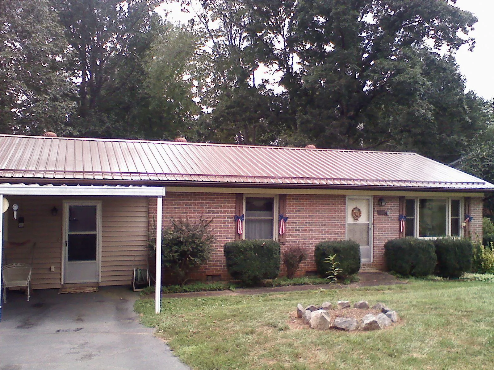 Bronze metal roof and carport on a brick ranch home — Roof Repair work by our crew in Englishtown